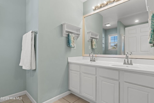 bathroom featuring baseboards, a sink, and tile patterned flooring