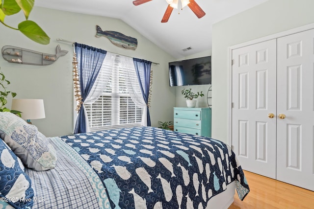 bedroom featuring vaulted ceiling, ceiling fan, visible vents, a closet, and wood finished floors