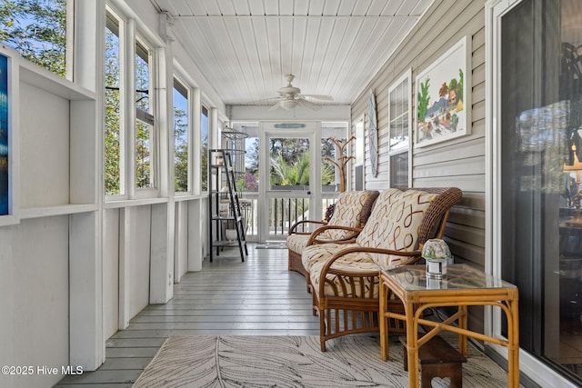 sunroom with wooden walls, ceiling fan, wood ceiling, and hardwood / wood-style floors