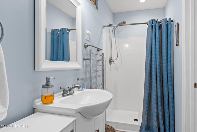 full bath with a stall shower, vanity, and radiator heating unit