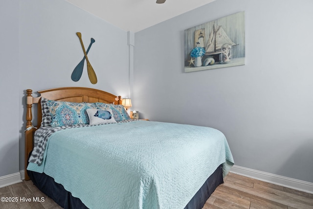 bedroom with baseboards, wood finished floors, and a ceiling fan
