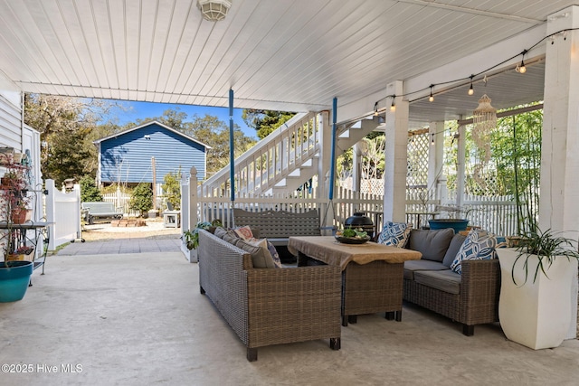 view of patio / terrace with outdoor lounge area, stairs, and fence