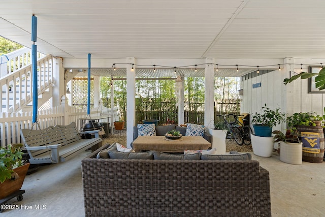 view of patio with an outdoor hangout area, fence, and stairway
