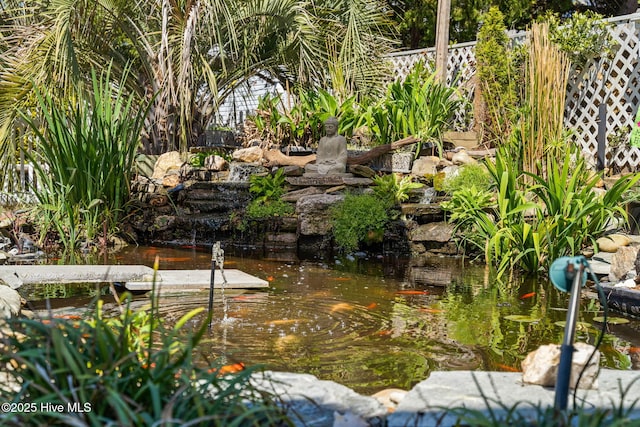 view of yard with fence and a small pond