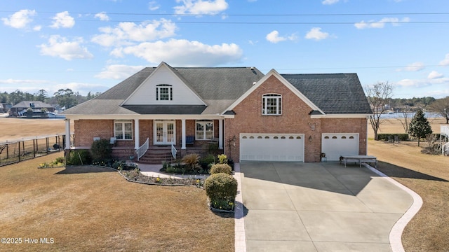 view of front of house featuring fence, driveway, a porch, french doors, and brick siding