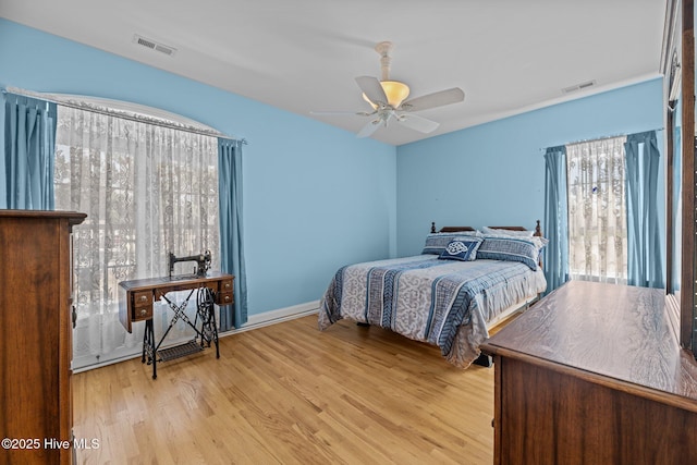 bedroom featuring ceiling fan, visible vents, and wood finished floors