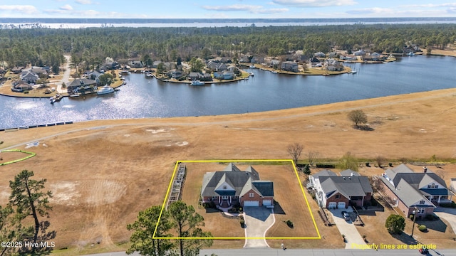 drone / aerial view featuring a forest view and a water view