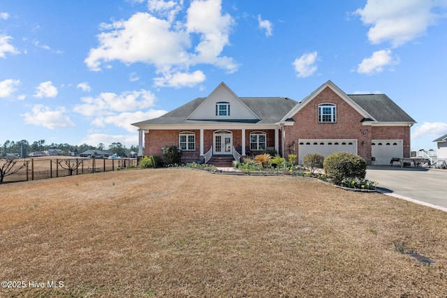 view of front of house featuring a front yard, fence, french doors, a garage, and brick siding