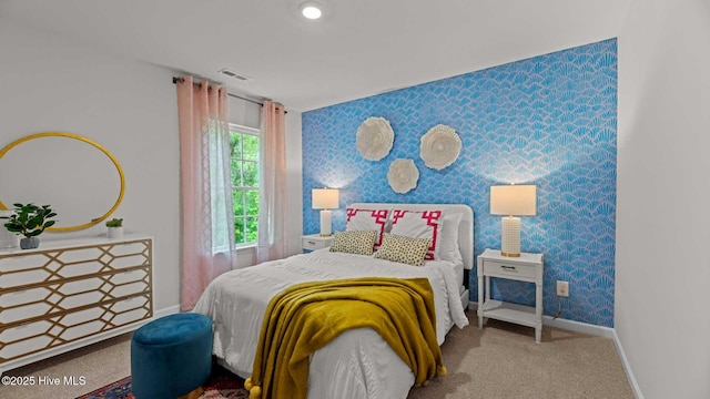 carpeted bedroom with wallpapered walls, visible vents, and baseboards