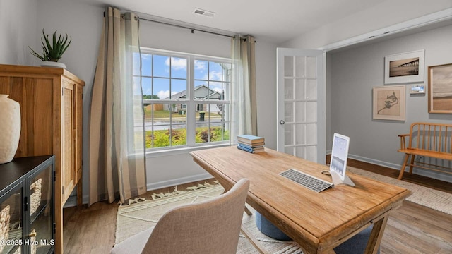 dining area featuring visible vents, baseboards, and wood finished floors