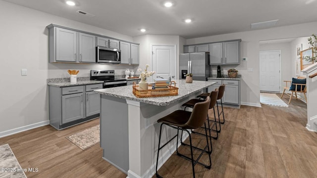 kitchen featuring light wood-style floors, appliances with stainless steel finishes, and gray cabinets