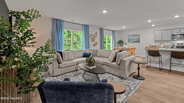 living room featuring recessed lighting, light wood-style flooring, and baseboards