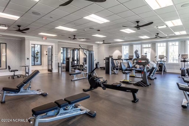 gym featuring baseboards, a drop ceiling, wallpapered walls, and ceiling fan