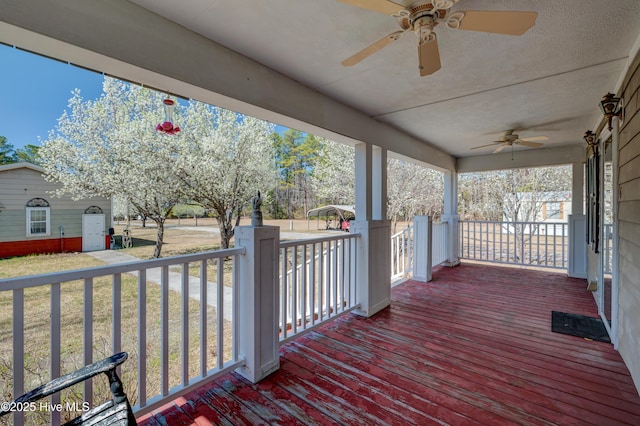 wooden deck with a lawn, covered porch, and ceiling fan