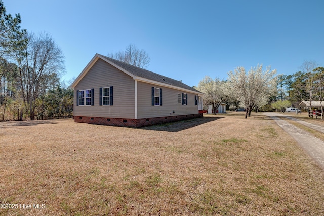 view of side of property featuring a yard and crawl space