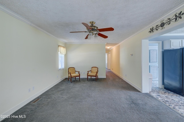 unfurnished room featuring visible vents, a textured ceiling, carpet flooring, and crown molding