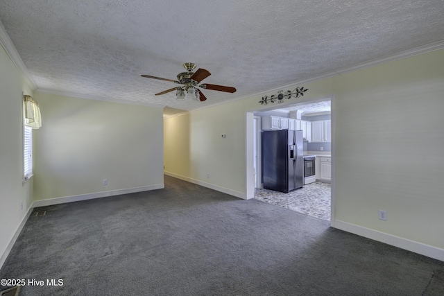 carpeted spare room with baseboards, a textured ceiling, ornamental molding, and a ceiling fan