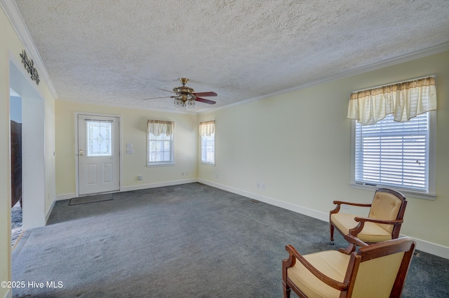 interior space featuring a wealth of natural light, dark carpet, a textured ceiling, and ornamental molding