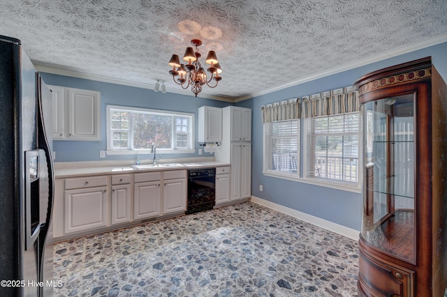 kitchen featuring a sink, black appliances, white cabinets, crown molding, and a chandelier