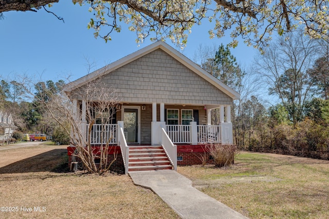 bungalow-style home featuring a front yard and covered porch