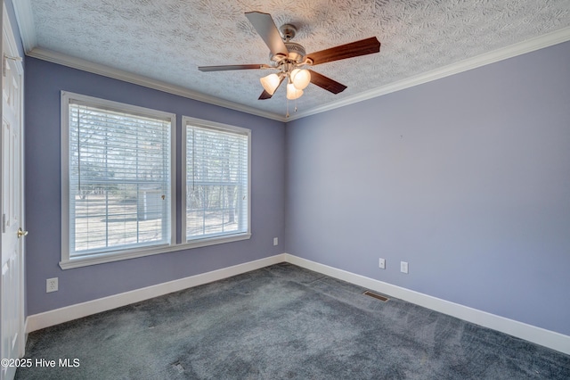 spare room with dark colored carpet, baseboards, a textured ceiling, and crown molding