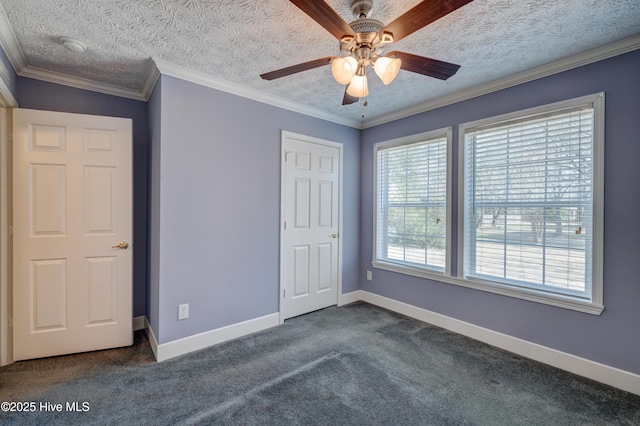 unfurnished bedroom with baseboards, a textured ceiling, ornamental molding, and dark carpet