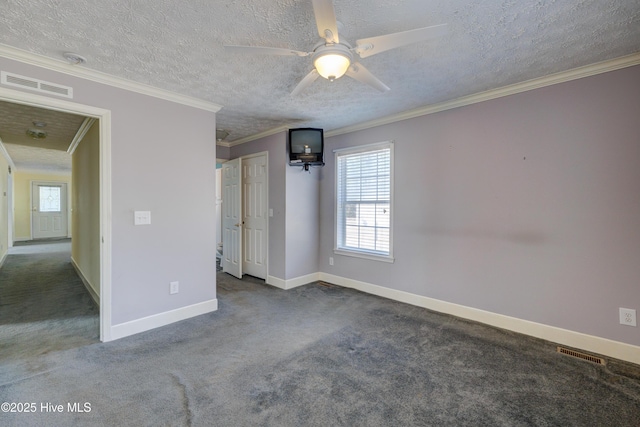 carpeted spare room featuring visible vents, a textured ceiling, baseboards, and ornamental molding