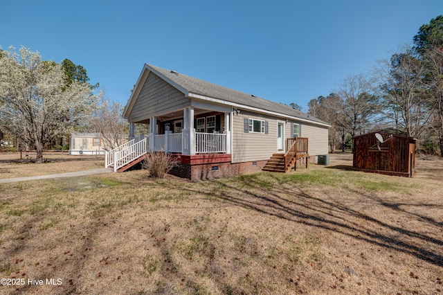 rear view of house with a porch, cooling unit, a lawn, and crawl space