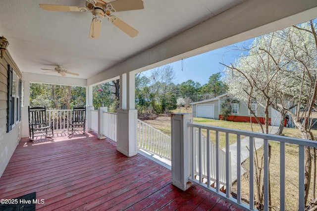 wooden deck featuring a yard, covered porch, and ceiling fan