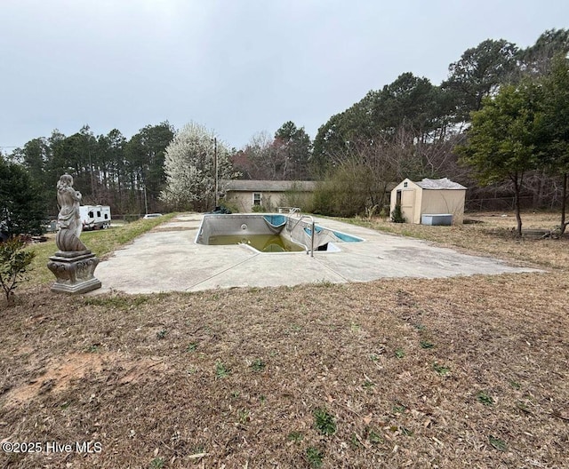 view of pool with a patio area, an outdoor structure, and a shed