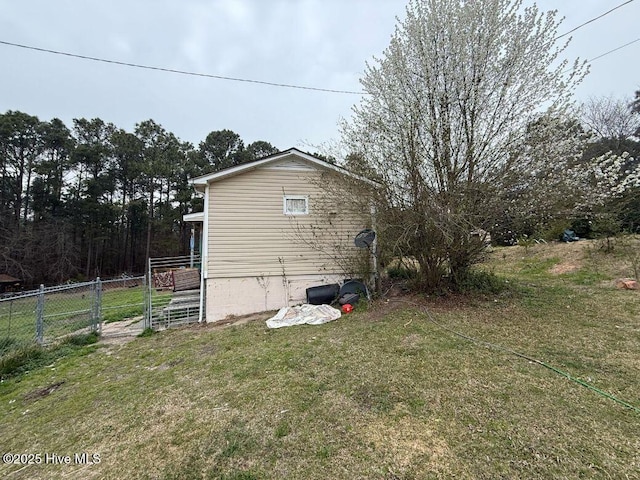 view of side of home with a lawn and fence