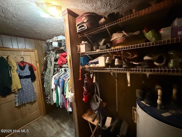 walk in closet with wood finished floors and water heater