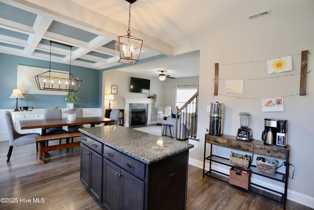 kitchen with beam ceiling, ceiling fan with notable chandelier, visible vents, and dark wood-style flooring