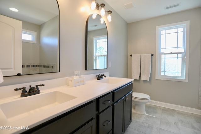 bathroom featuring a sink, visible vents, baseboards, and toilet