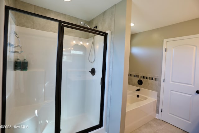 bathroom featuring a stall shower, tile patterned flooring, and a bath