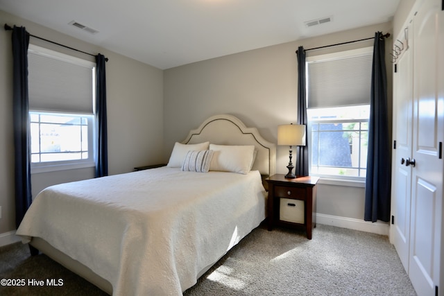 bedroom featuring visible vents, multiple windows, and carpet floors