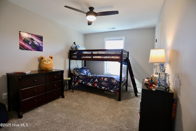 carpeted bedroom featuring visible vents, baseboards, and a ceiling fan