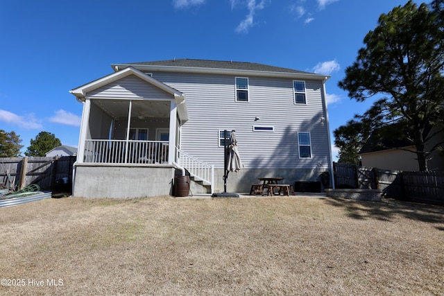 back of house featuring a fenced backyard and a sunroom