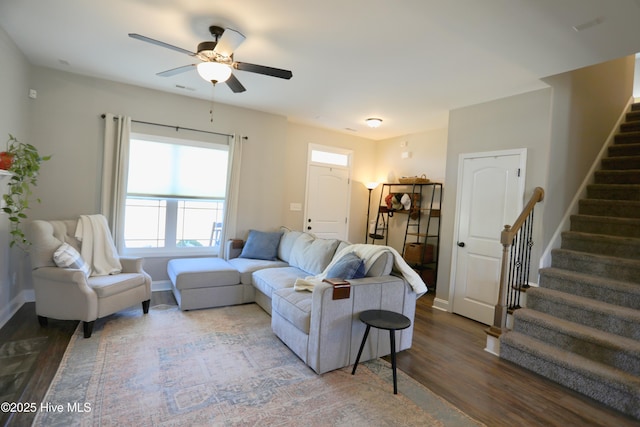 living area featuring stairway, baseboards, wood finished floors, and a ceiling fan