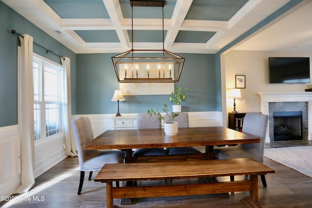 dining space featuring beam ceiling, wood finished floors, and wainscoting