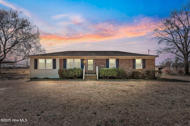 single story home with a front yard and brick siding