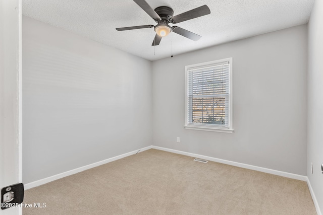 unfurnished room with baseboards, visible vents, a textured ceiling, and carpet