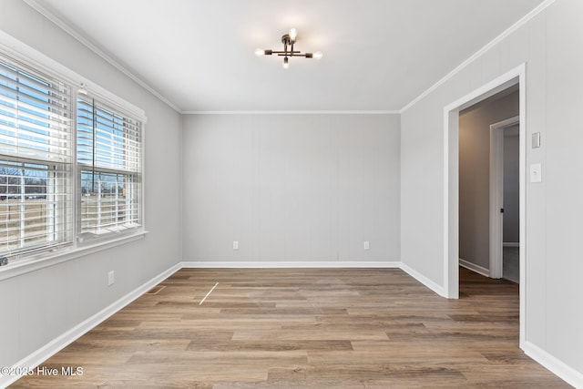 unfurnished room with baseboards, wood finished floors, and crown molding