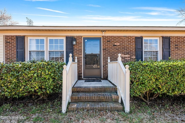 doorway to property featuring brick siding