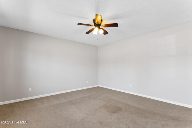 carpeted empty room with baseboards and ceiling fan