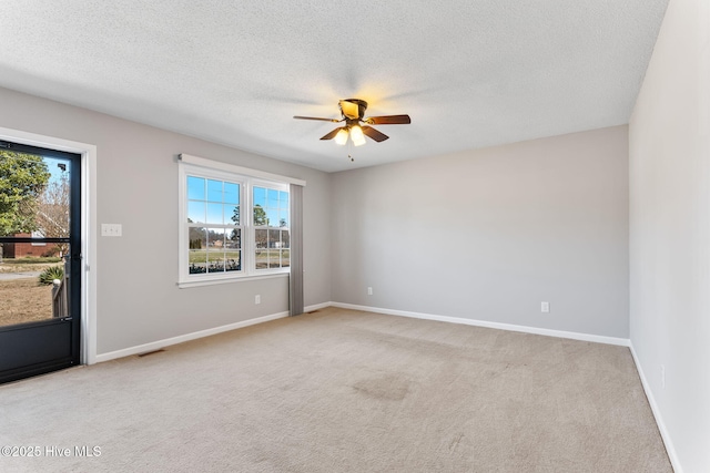 unfurnished room with visible vents, baseboards, ceiling fan, light carpet, and a textured ceiling