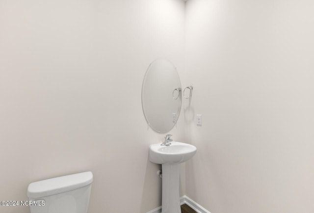 bathroom featuring toilet and baseboards