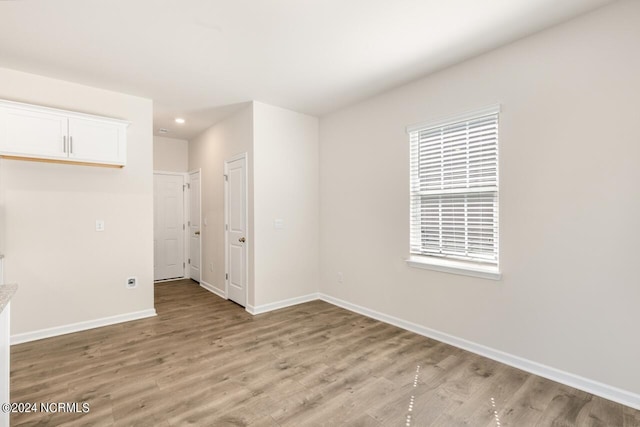 empty room with recessed lighting, light wood-style floors, and baseboards