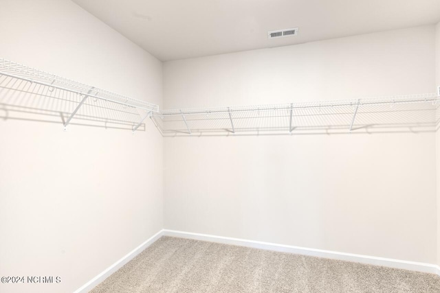 walk in closet with light carpet and visible vents