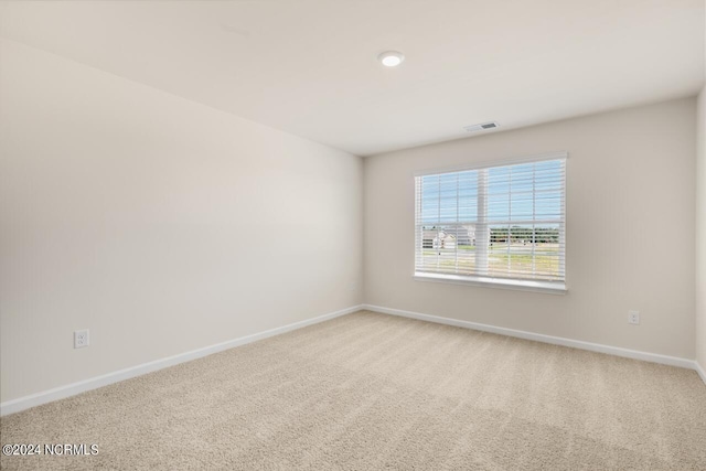 carpeted empty room featuring visible vents and baseboards